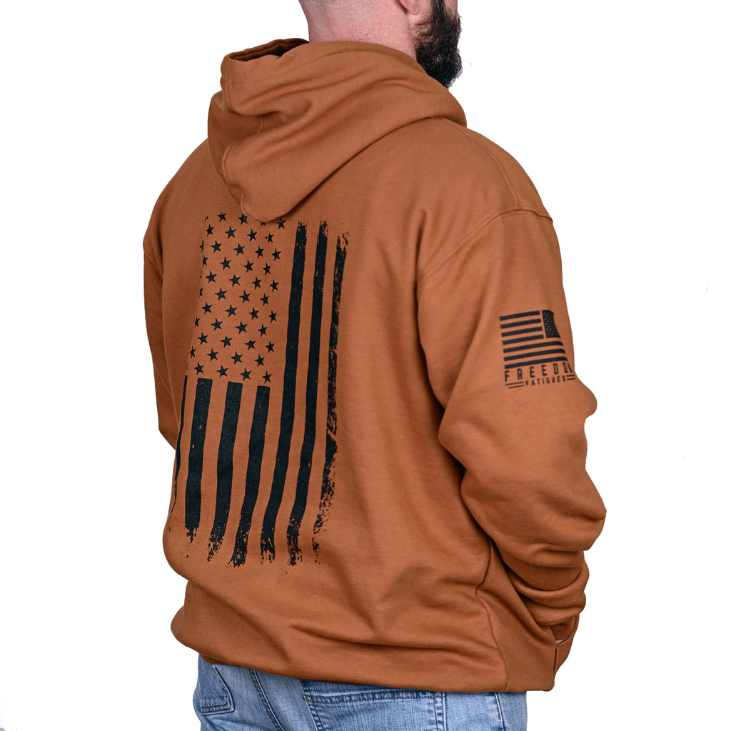 Caramel brown hoodie with American flag design on the back and sleeve, worn by a male model