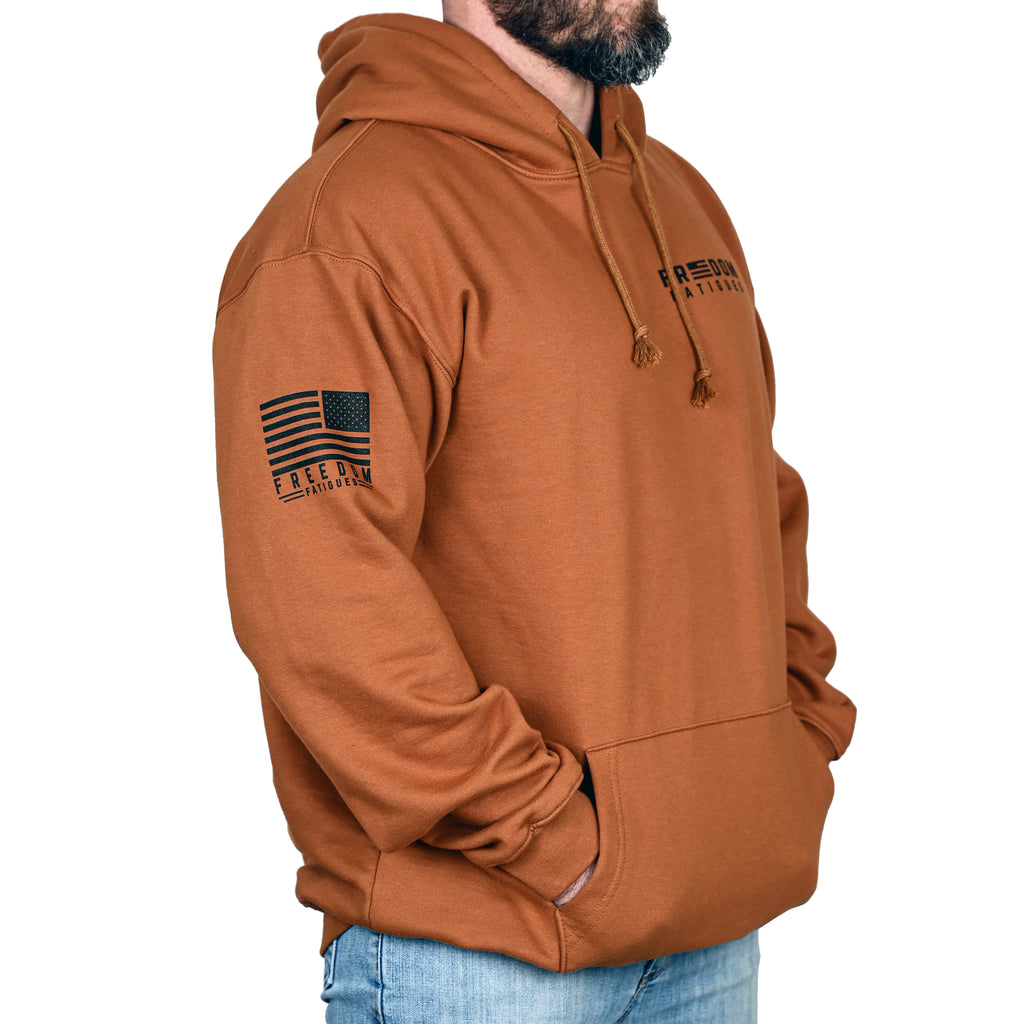 Caramel brown hoodie with an American flag on the sleeve and brand logo on chest, worn by a male model