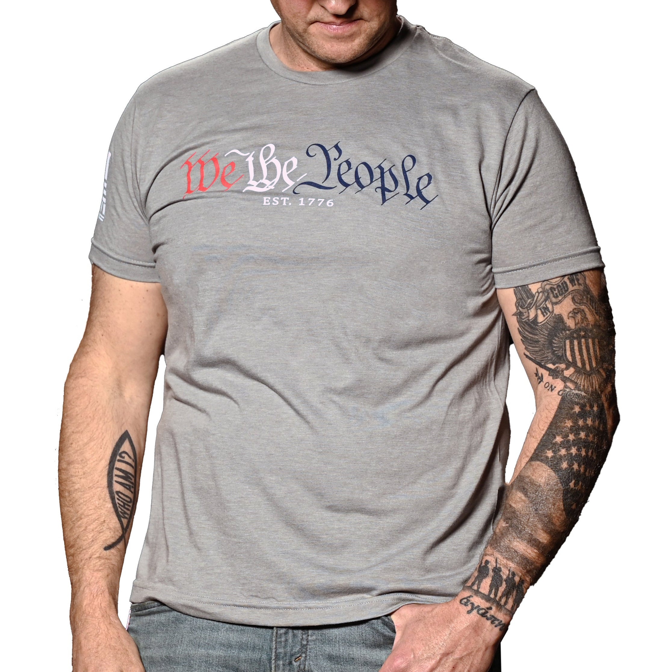 A man wearing the patriotic 'We The People' gray crew neck t-shirt with text in red and blue. (front view)