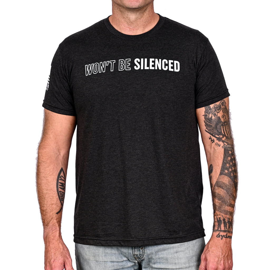 Man wearing a patriotic black t-shirt with "won't be silenced" across the front.
