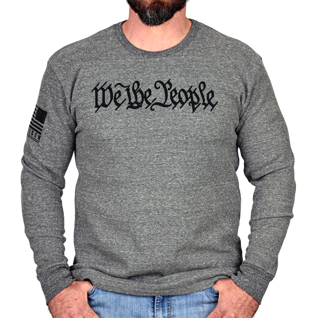 Gray long-sleeve thermal with 'We The People' on the front and Freedom Fatigues logo on the sleeve and worn by a male model