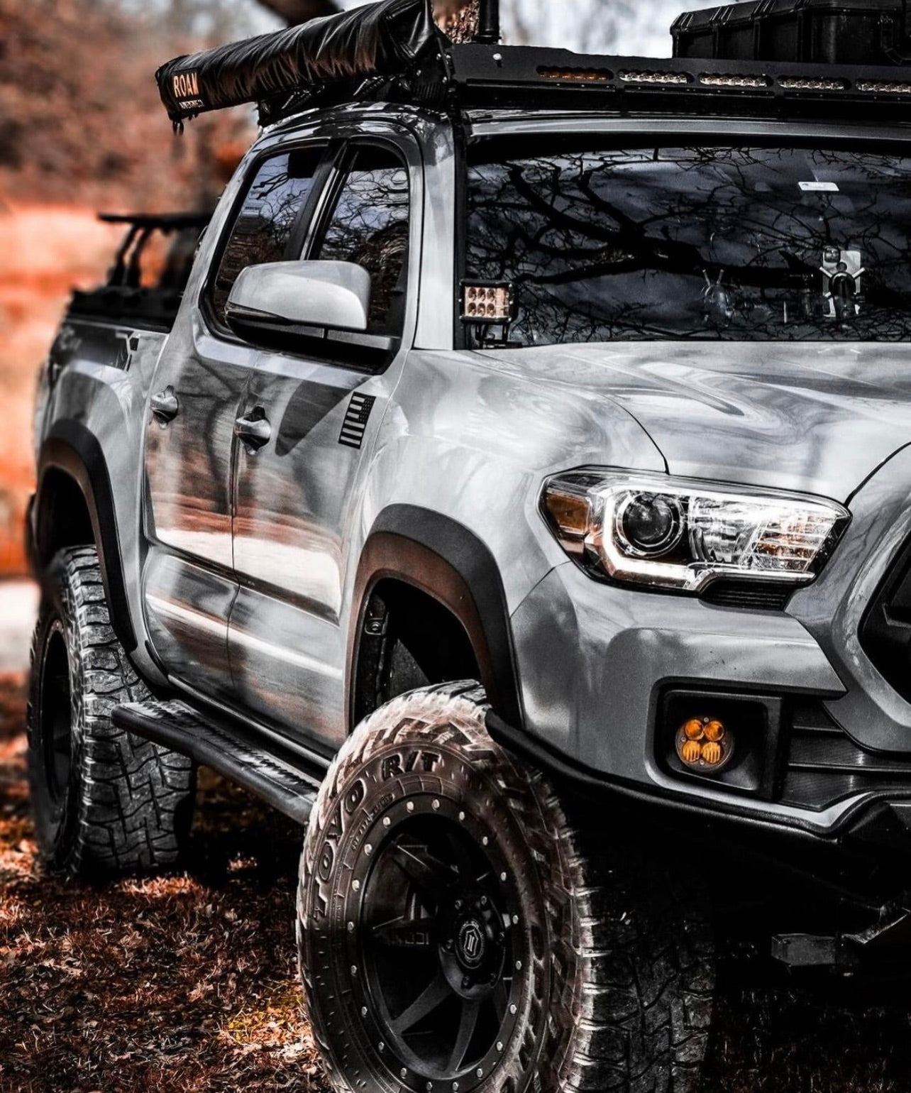 Silver pickup truck with off-road equipment in a natural setting
