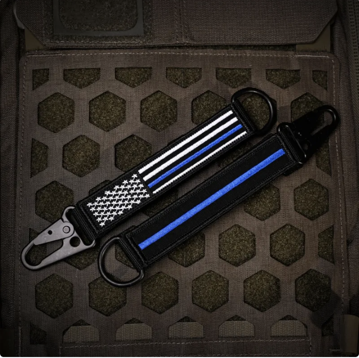 Thin blue line keychain with American flag design on a tactical pouch.