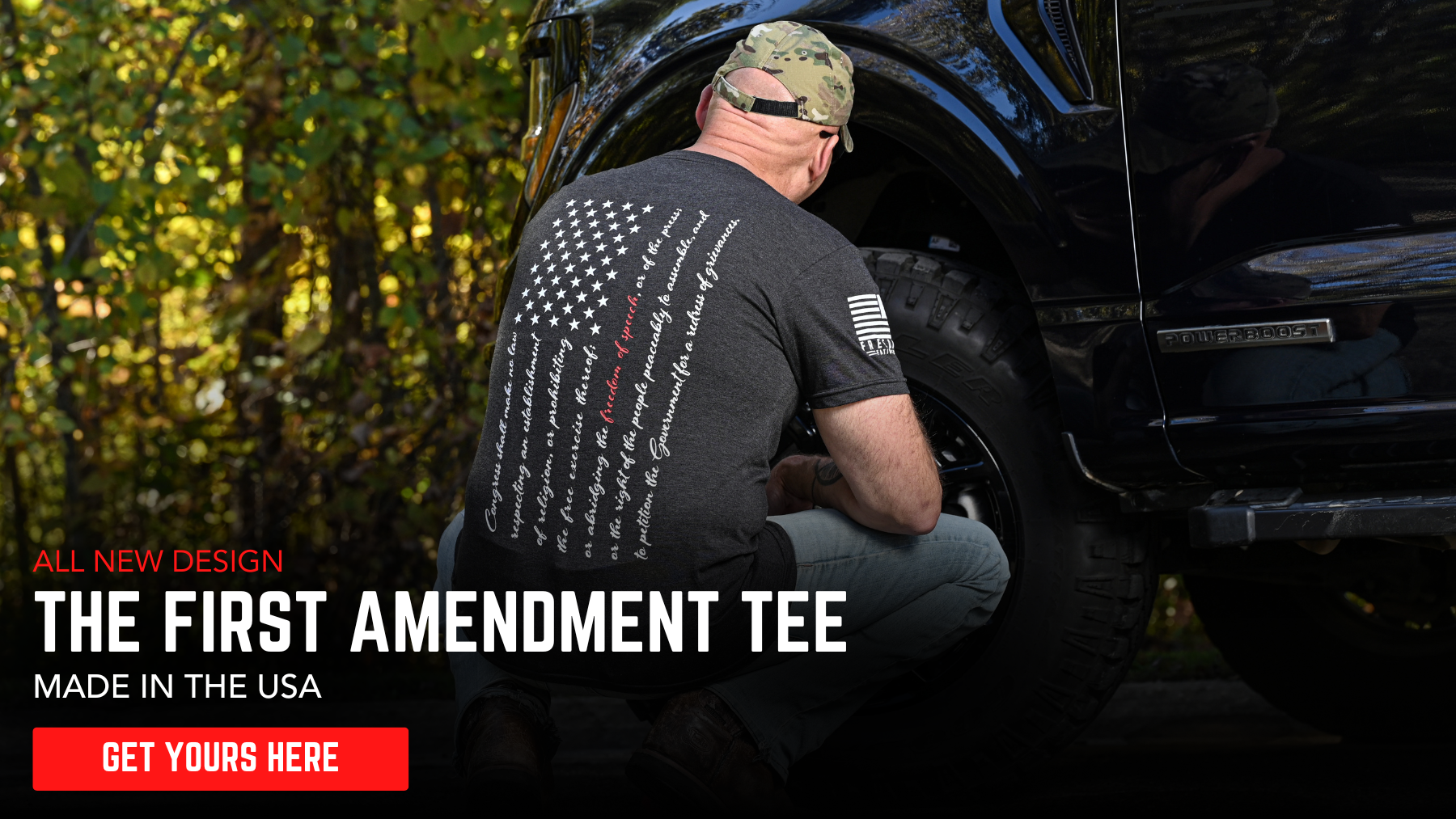 Man working on a vehicle with text about a 'First Amendment Tee' made in the USA.