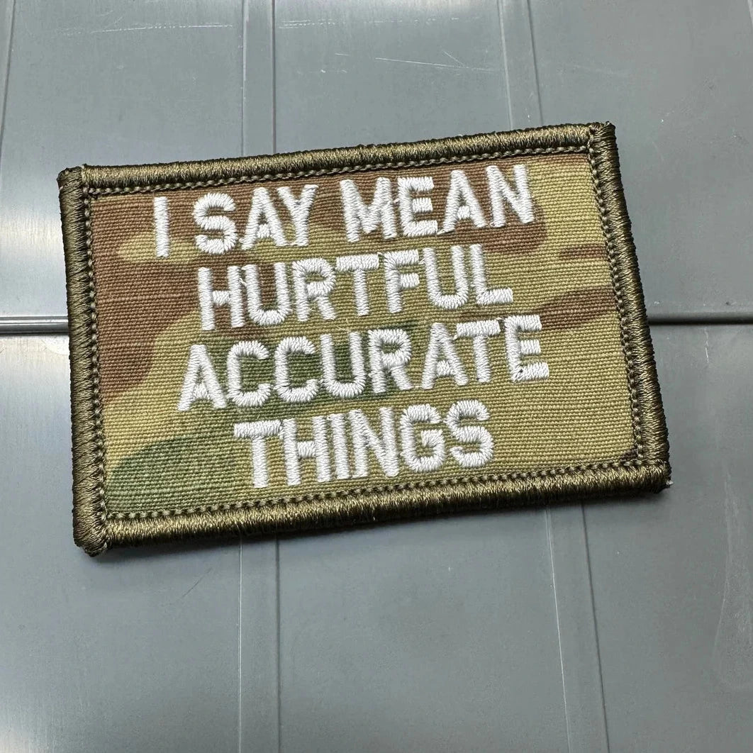 Camouflage patch with text 'I SAY MEAN HURTFUL ACCURATE THINGS' on a metallic surface