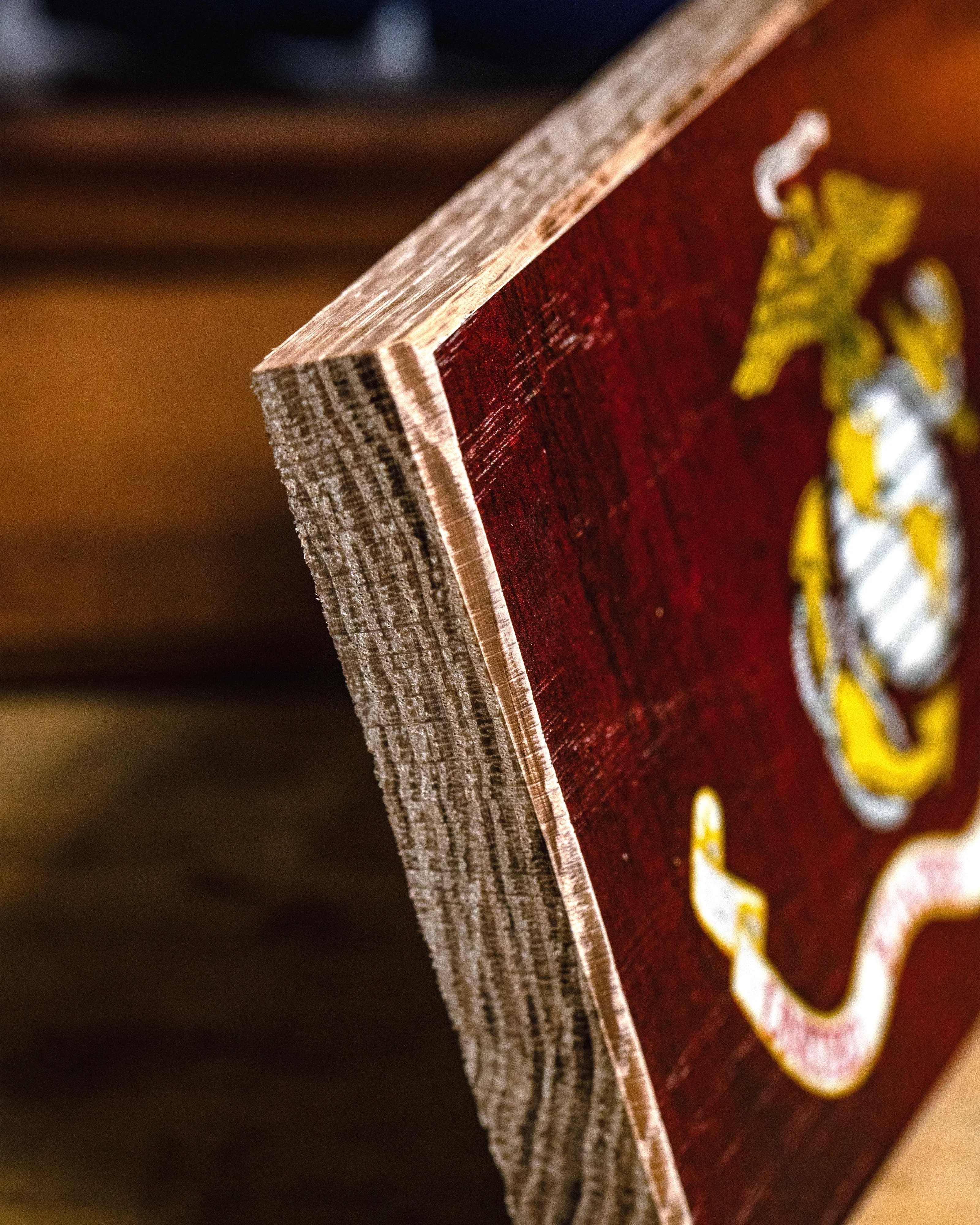 Close-up of a wooden plaque with a military emblem on a blurred background